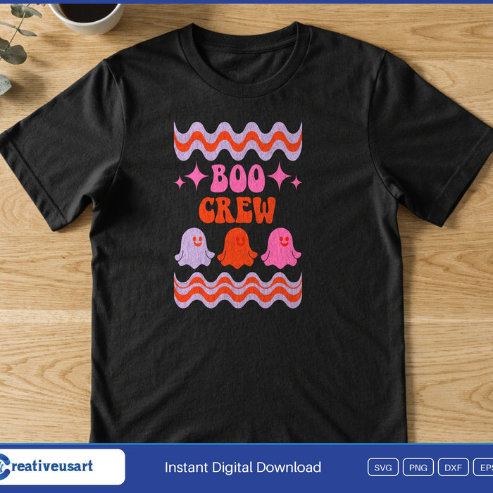 Three small pink and orange ghosts under the words Boo Crew, between wavy retro stripes, on a black t-shirt