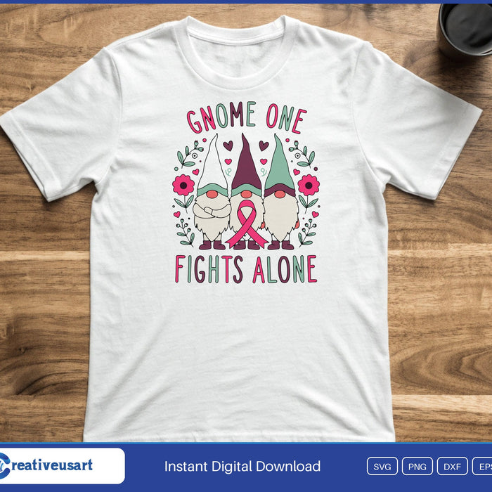 Three gnomes with pink ribbons and flowers between the words Gnome One Fights Alone, on a white t-shirt