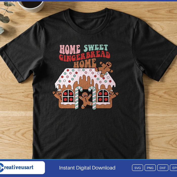 A frosted gingerbread house with candy canes and gingerbread men under the words Home Sweet Gingerbread Home, on a black t-shirt