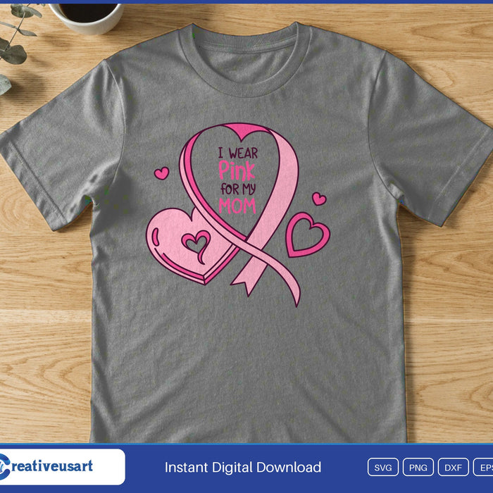 A pink ribbon looping into a heart with small hearts around it, holding the words I Wear Pink For My Mom, on a gray t-shirt