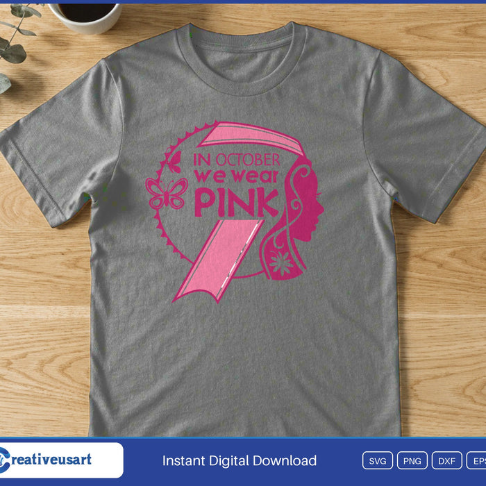 A woman's profile inside a pink awareness ribbon with the words In October We Wear Pink, on a gray t-shirt