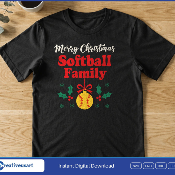 A softball ornament with a red bow and holly under the words Merry Christmas Softball Family, on a black t-shirt