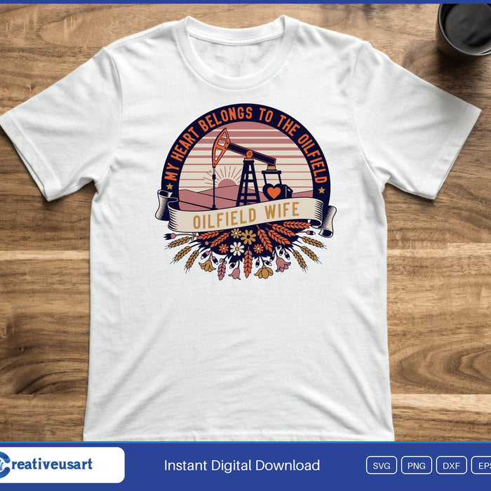 A pump jack in a sunrise badge with the words My Heart Belongs To The Oilfield and Oilfield Wife, on a white t-shirt