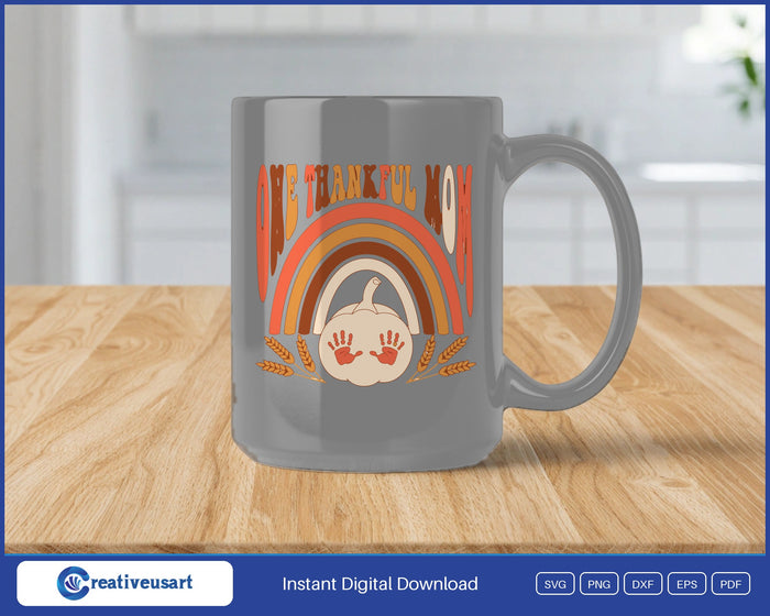 One Thankful Mom retro rainbow with a pumpkin and handprints SVG design on a gray coffee mug