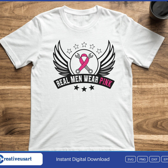 A winged badge with a pink ribbon over crossed wrenches, above a banner reading Real Men Wear Pink, on a white t-shirt
