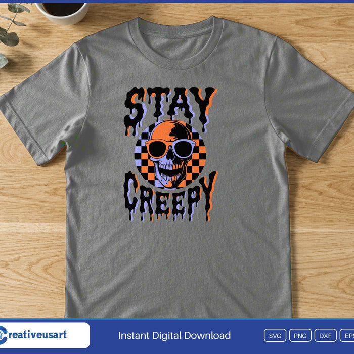 A checkered skull in sunglasses between the dripping words Stay Creepy, on a gray t-shirt