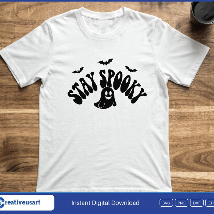 The words Stay Spooky in wavy retro letters with a small ghost and bats, on a white t-shirt